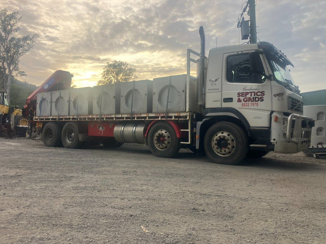 A Large Truck is Parked in a Gravel Lot — Graham's Precast Concrete Products Pty Ltd in Kyogle, NSW