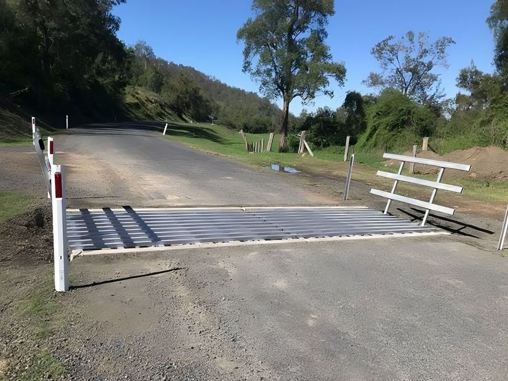 A Metal Fence is Sitting on the Side of a Road — Graham's Precast Concrete Products Pty Ltd in Kyogle, NSW