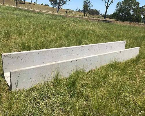 Two white concrete blocks are sitting on top of a lush green field.