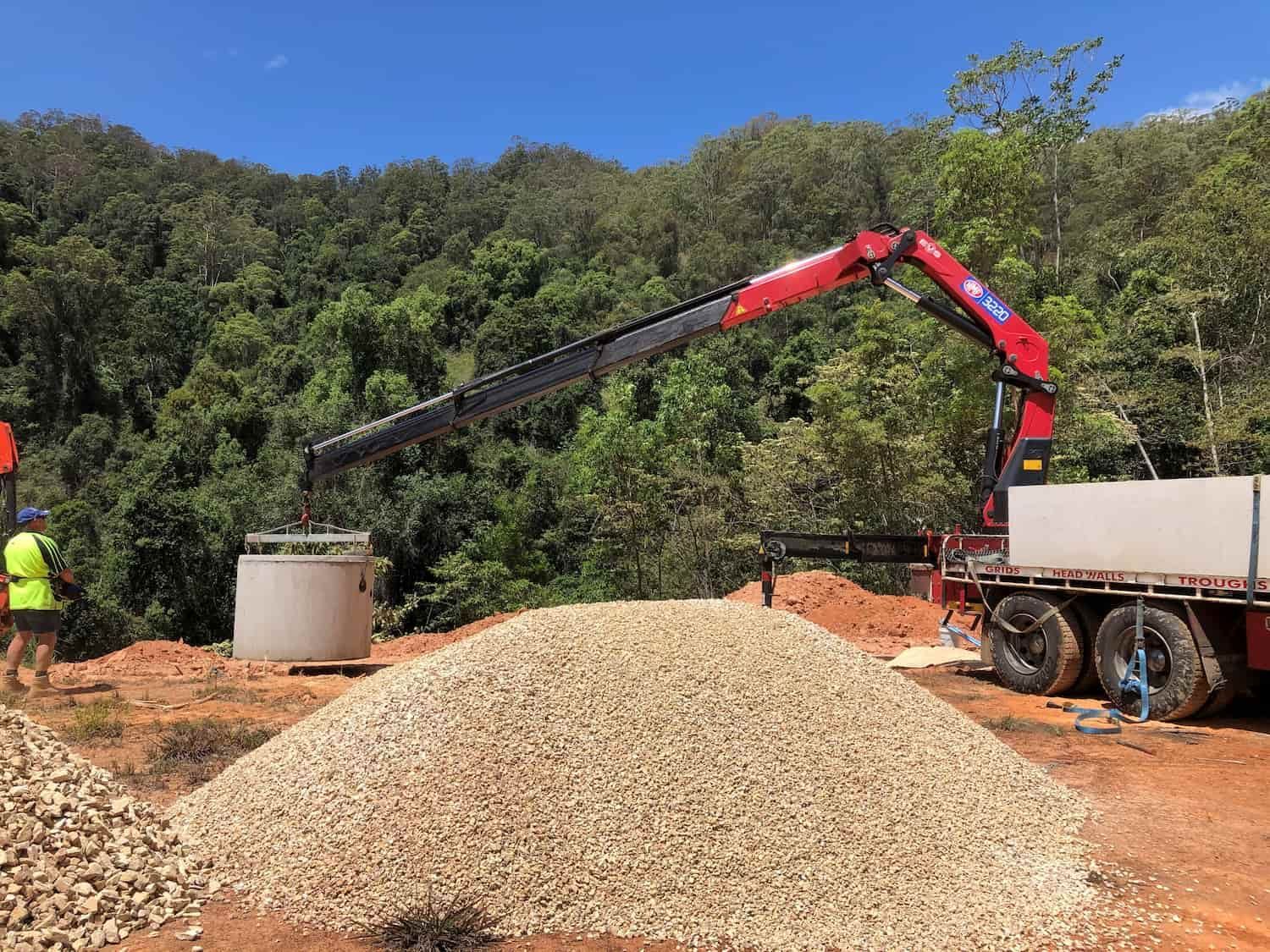 A Crane is Lifting a Pile of Gravel From a Truck — Graham's Precast Concrete Products Pty Ltd in Kyogle, NSW