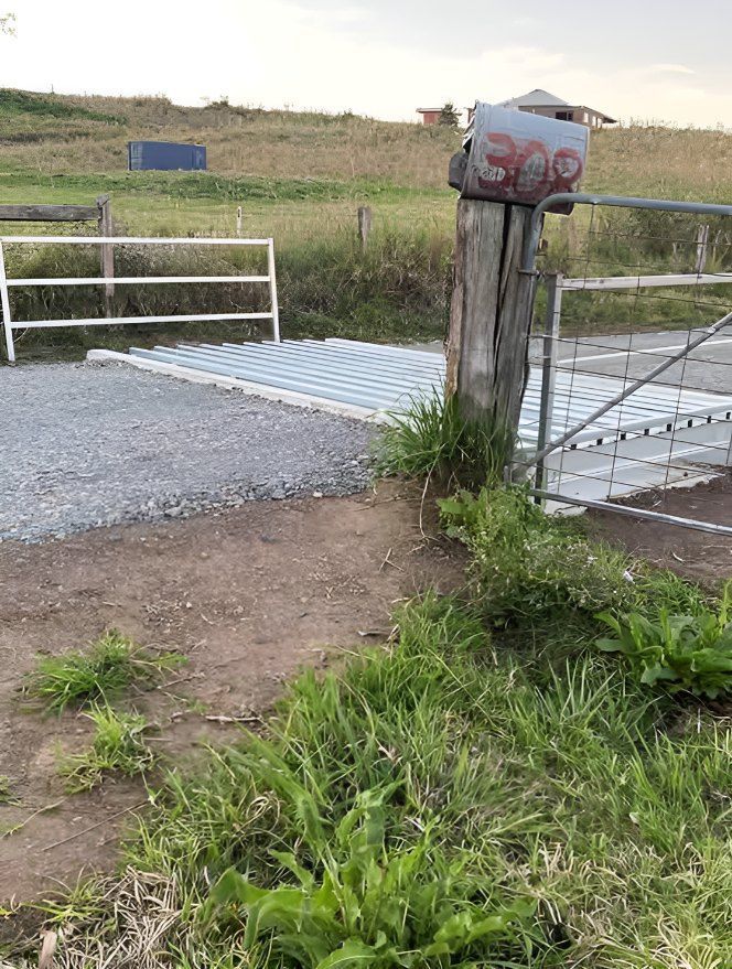 A Mailbox is Sitting Next to a Gate in a Field — Graham's Precast Concrete Products Pty Ltd in Kyogle, NSW