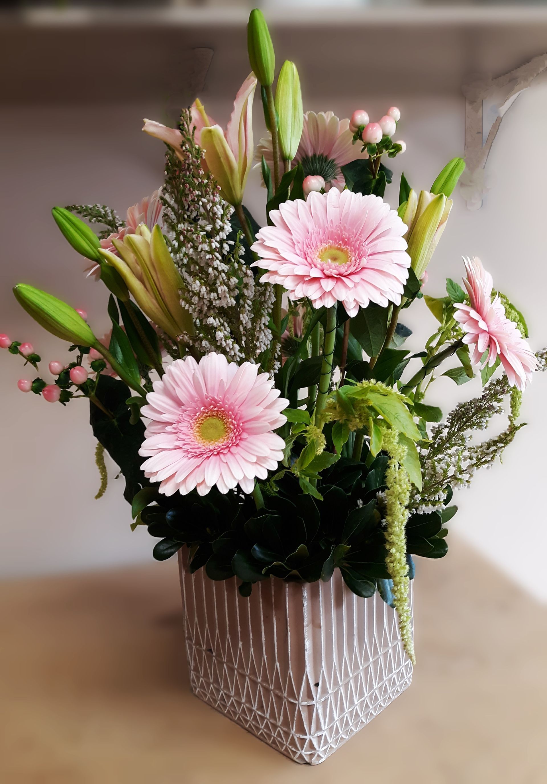 A vase filled with pink flowers is sitting on a table.