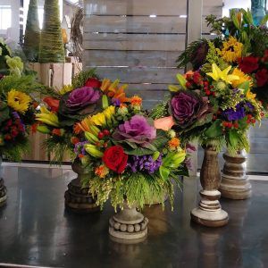 Three vases filled with flowers are sitting on a table.