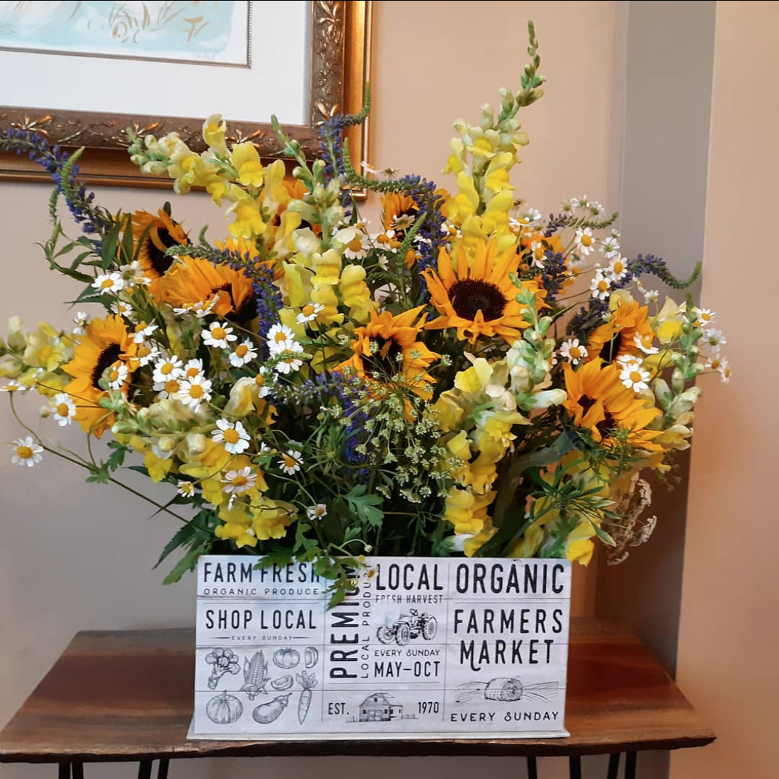 A bouquet of flowers on a table with a sign that says local organic farmers market