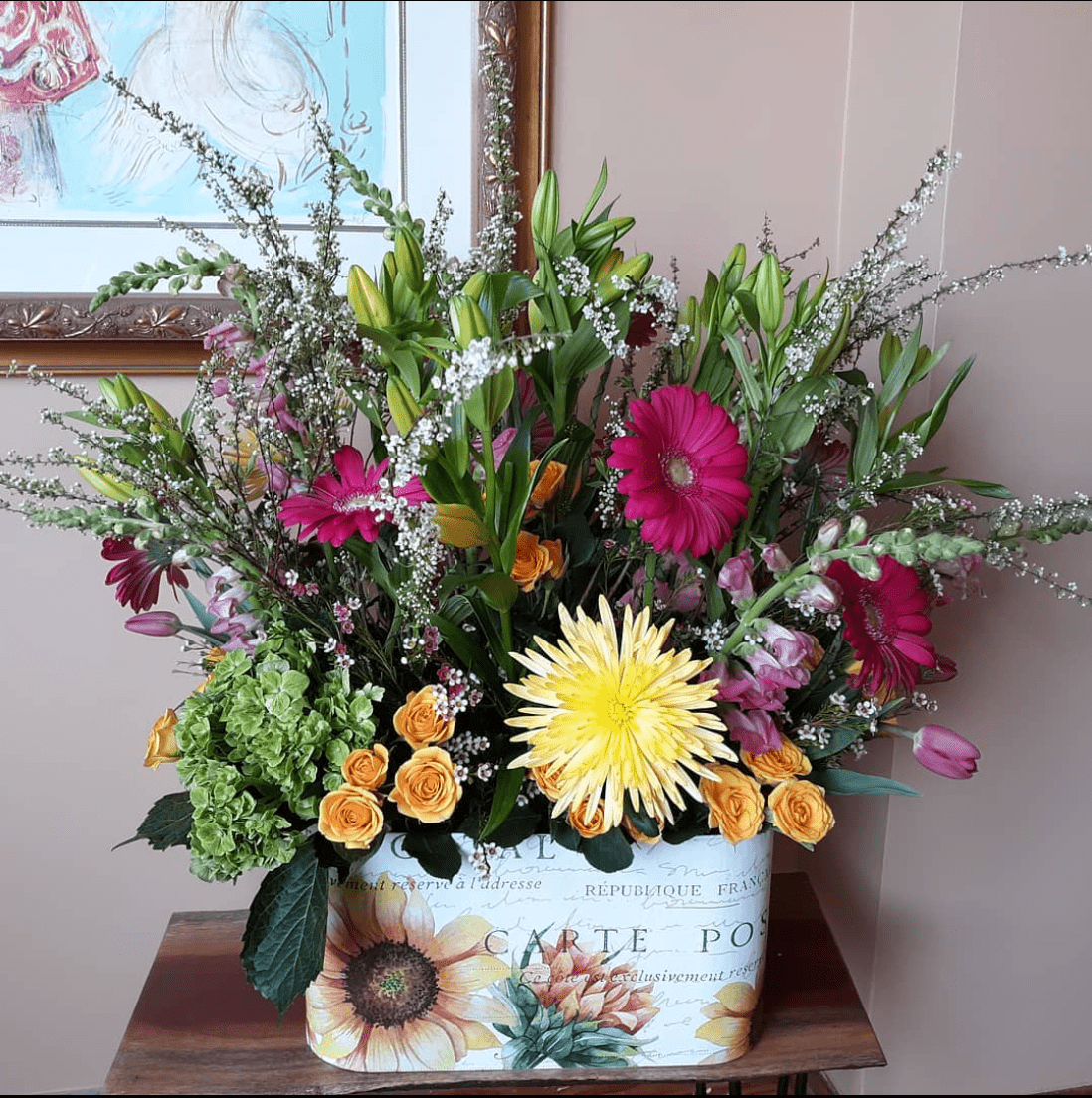 A vase filled with flowers is sitting on a wooden table.