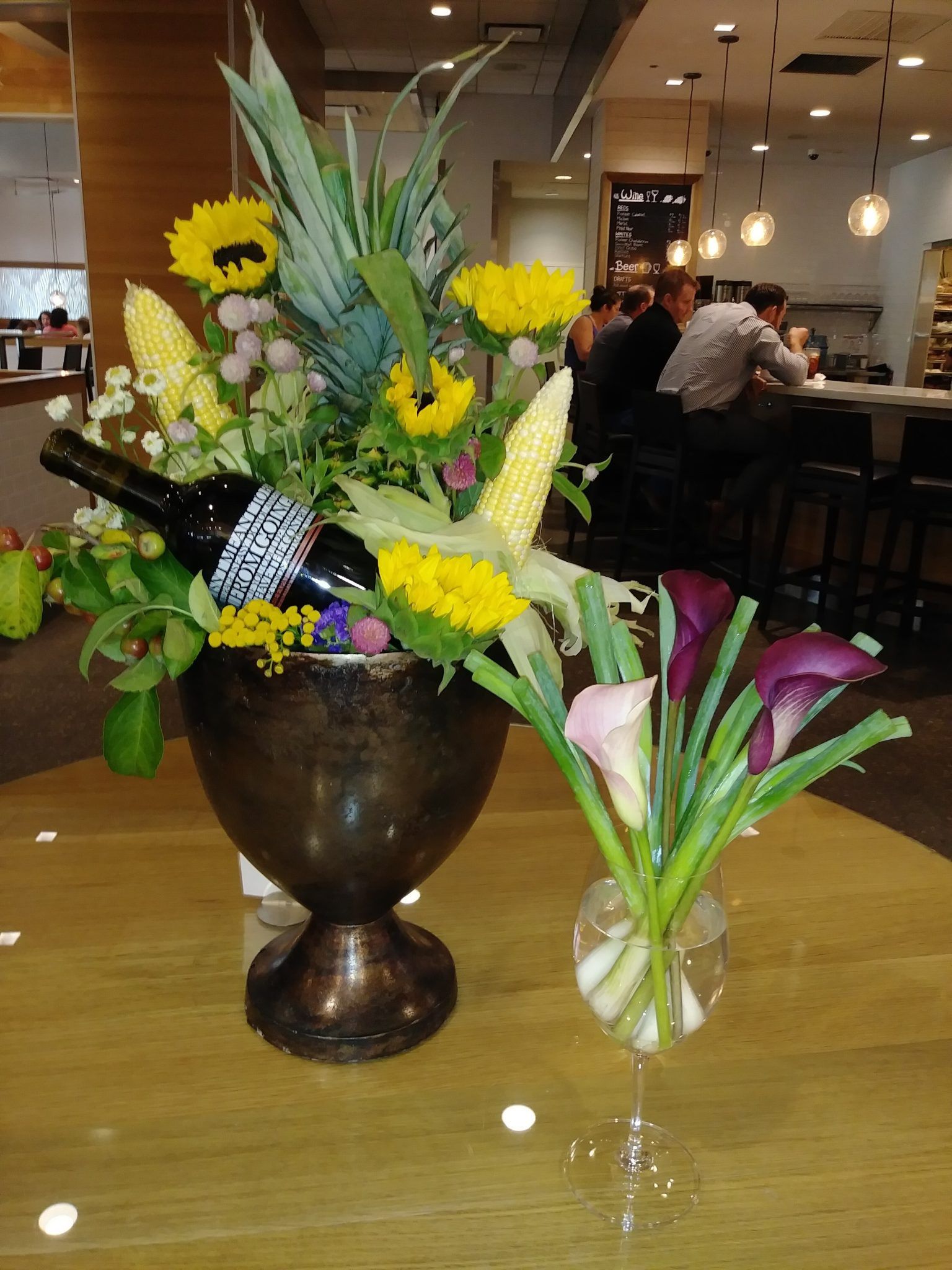 A vase of flowers with a bottle of wine in it