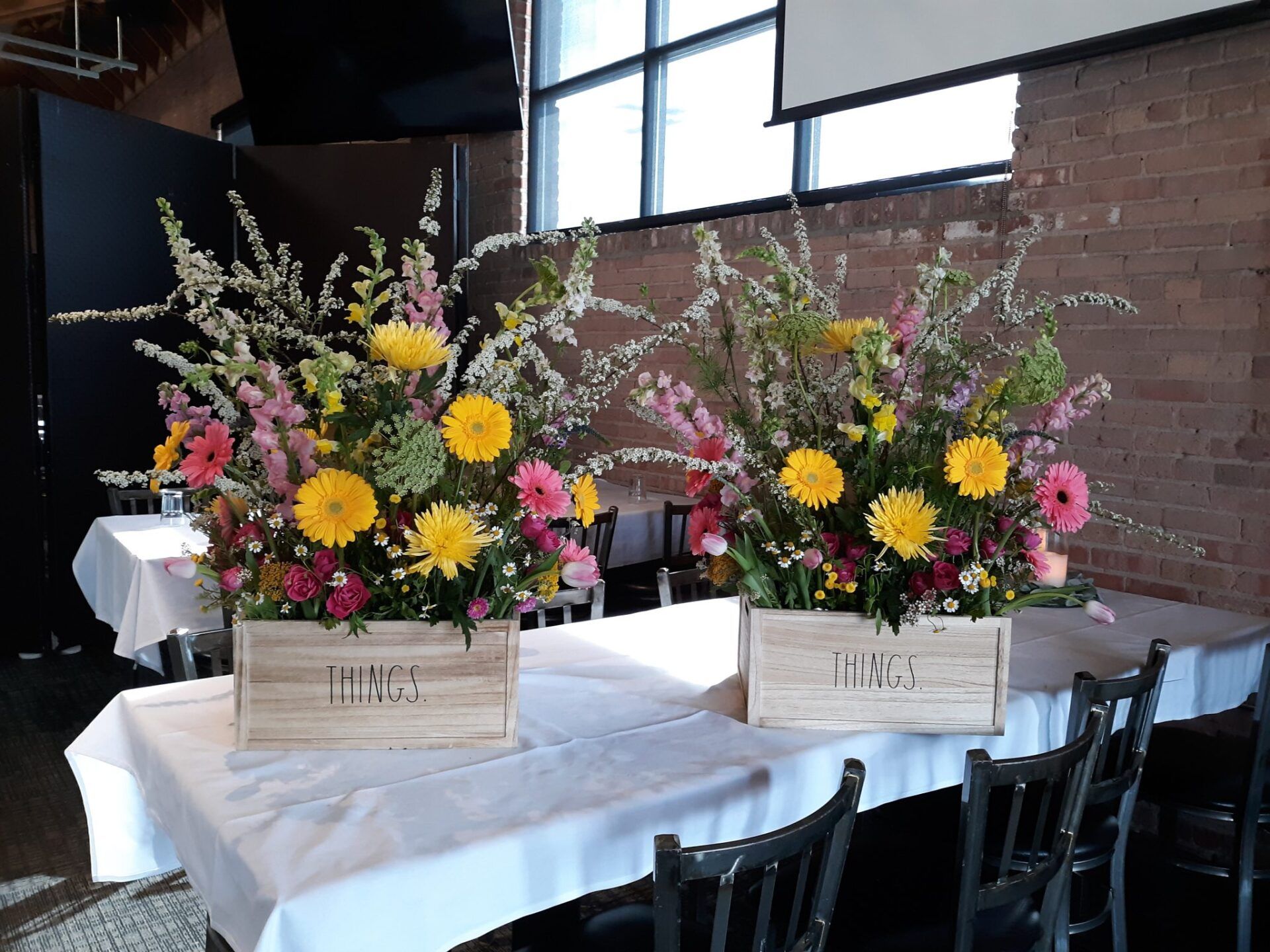Two wooden boxes filled with flowers are sitting on a table.