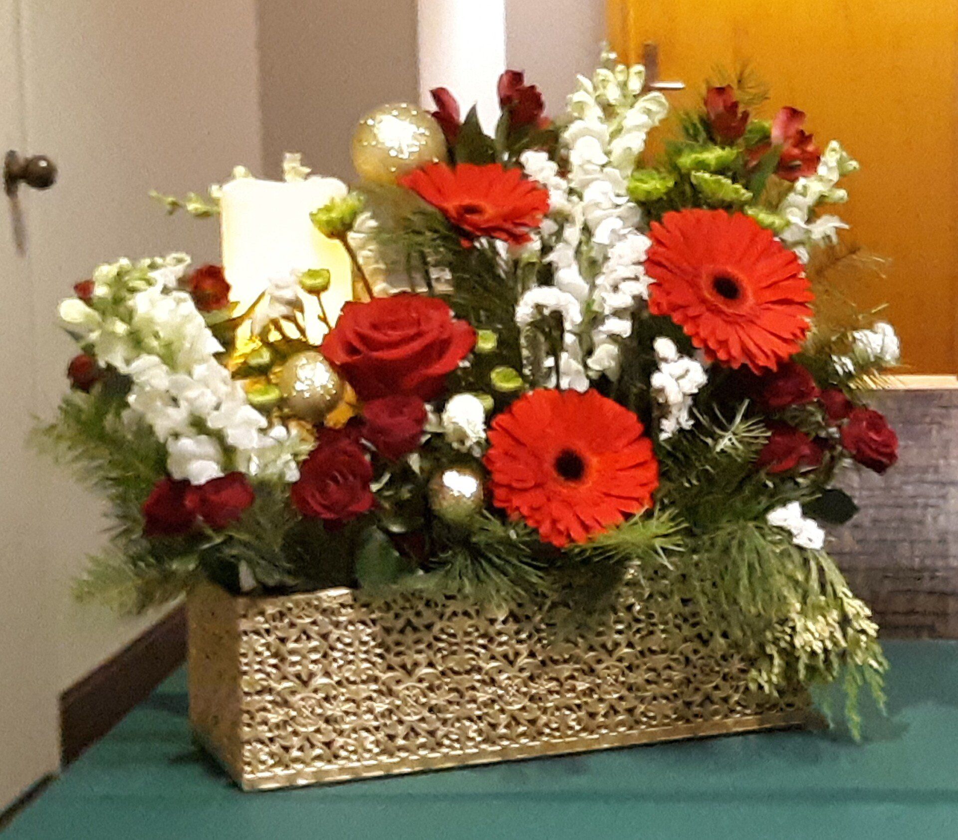 A vase filled with red and white flowers sits on a table