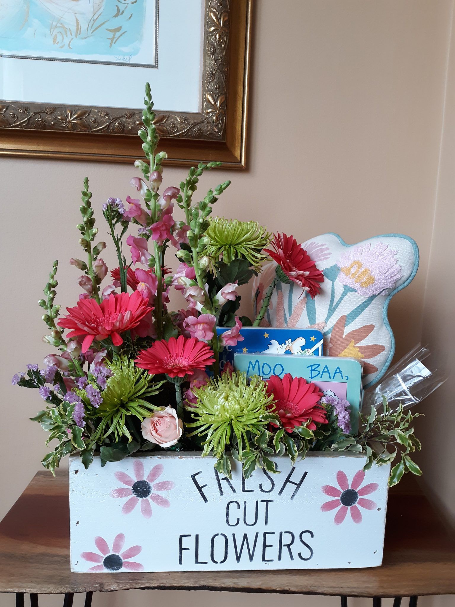 A box of fresh cut flowers is sitting on a table.
