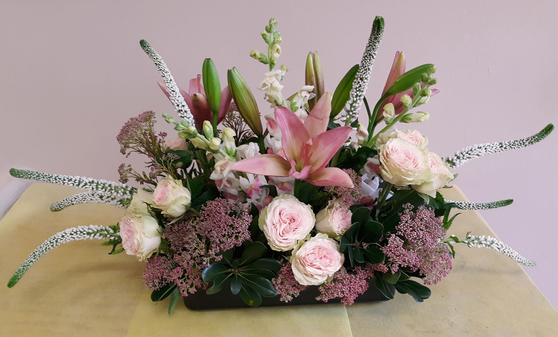 A vase filled with pink and white flowers on a table