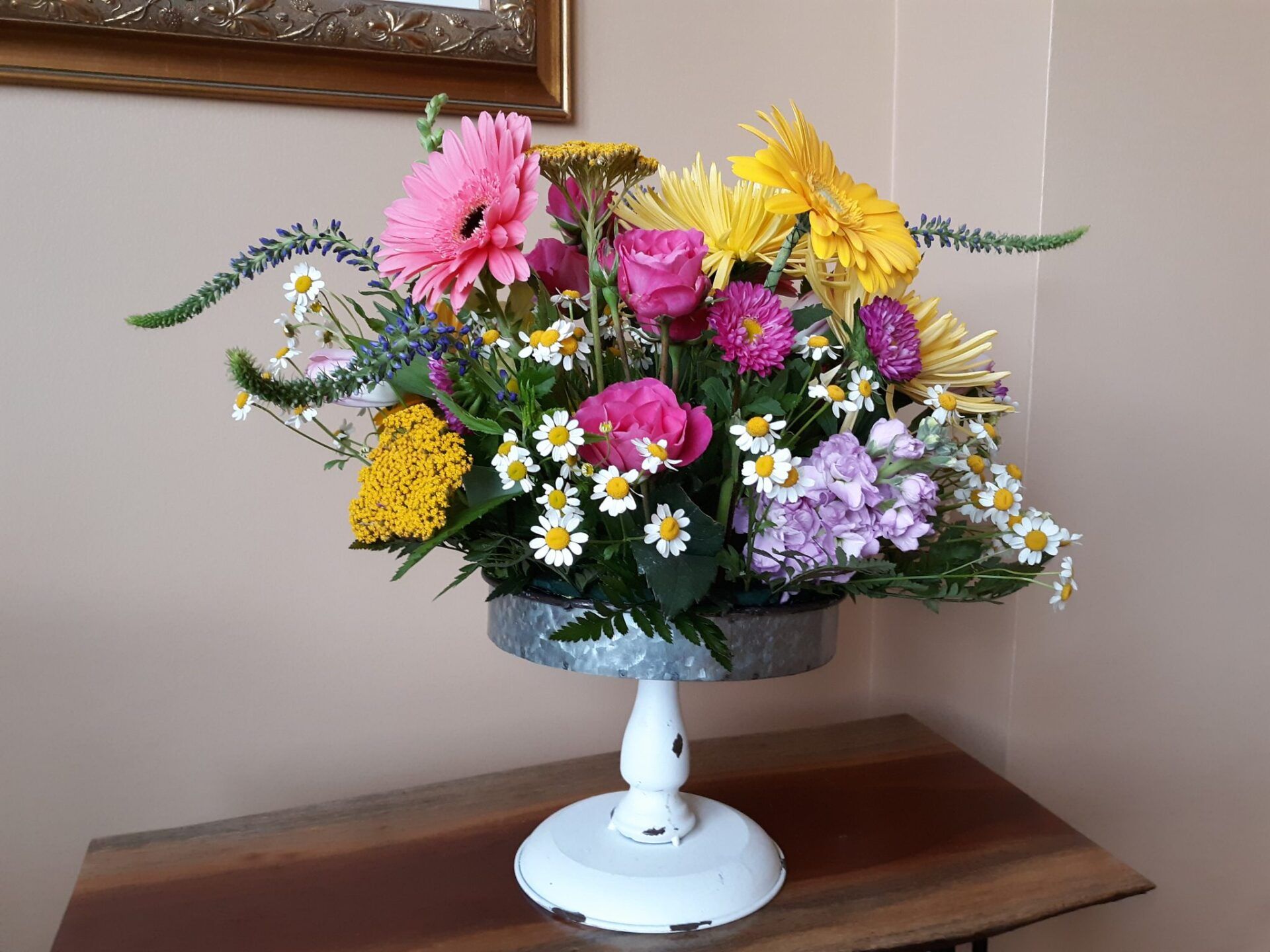 A vase filled with flowers is sitting on a wooden table.