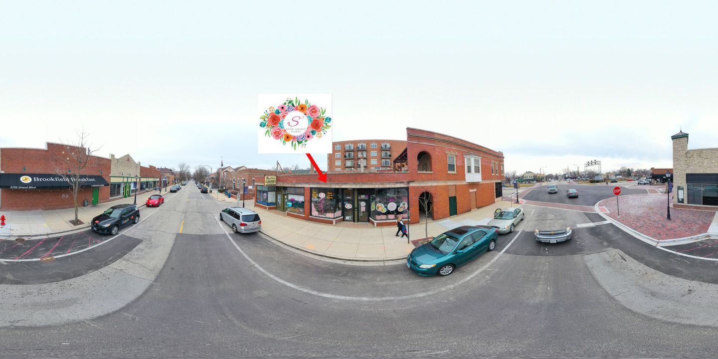 A 360 degree view of a city street with a kite flying in the sky.