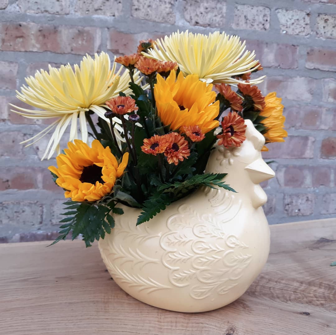 A vase with flowers in it that looks like a chicken head