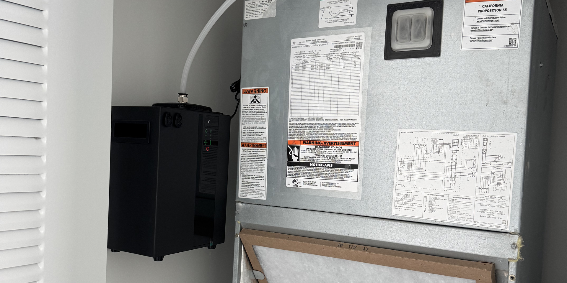 A refrigerator is sitting in a closet next to a wall.