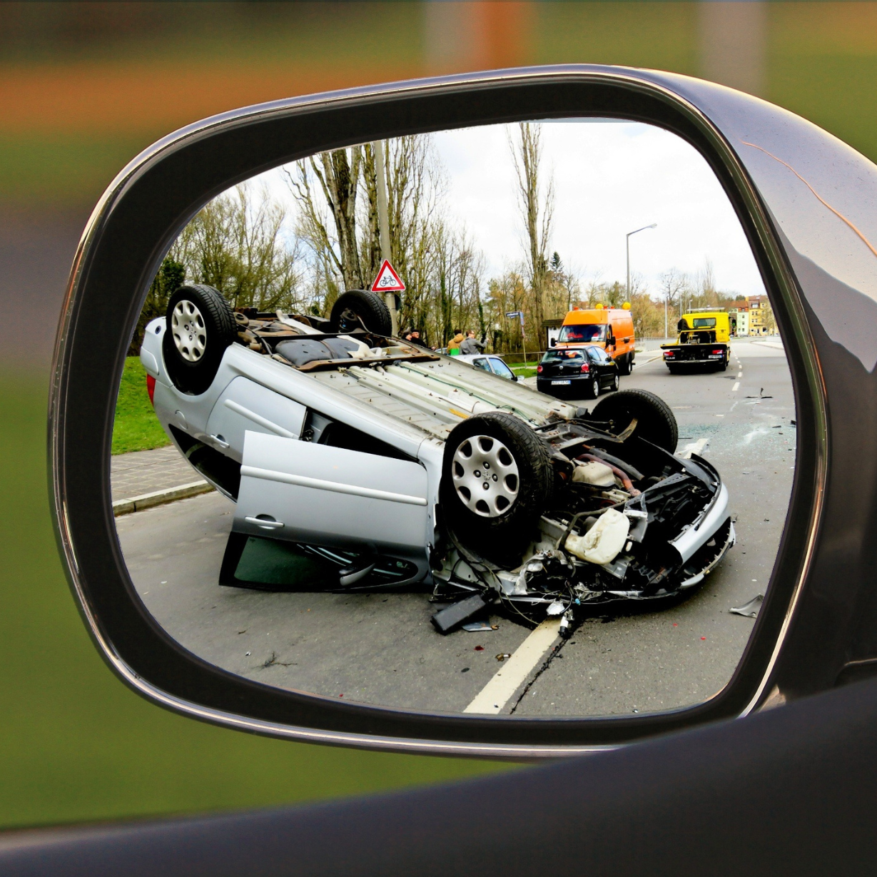 a car accident is reflected in a rear view mirror
