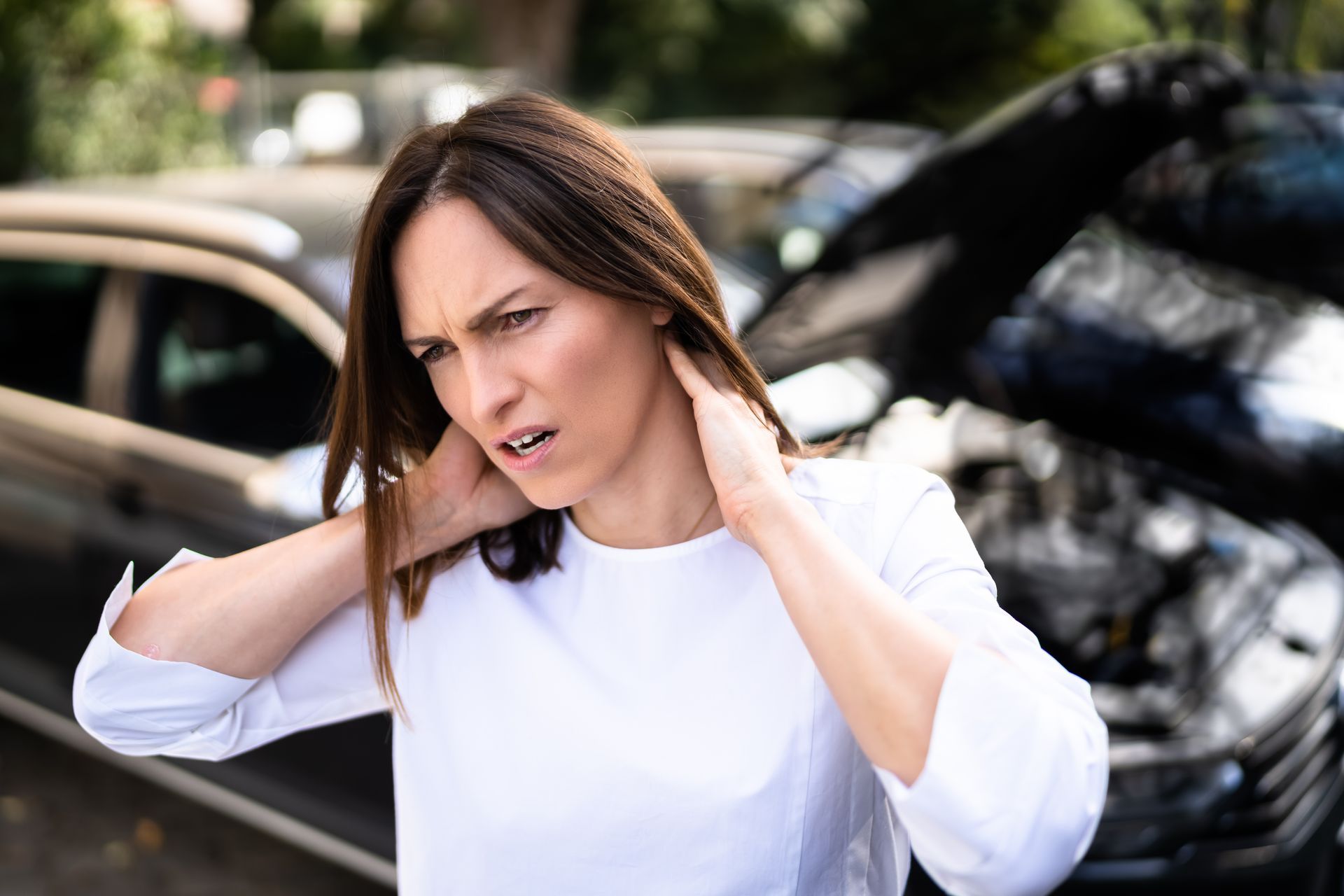 A woman in a car accident holding her neck in pain. 