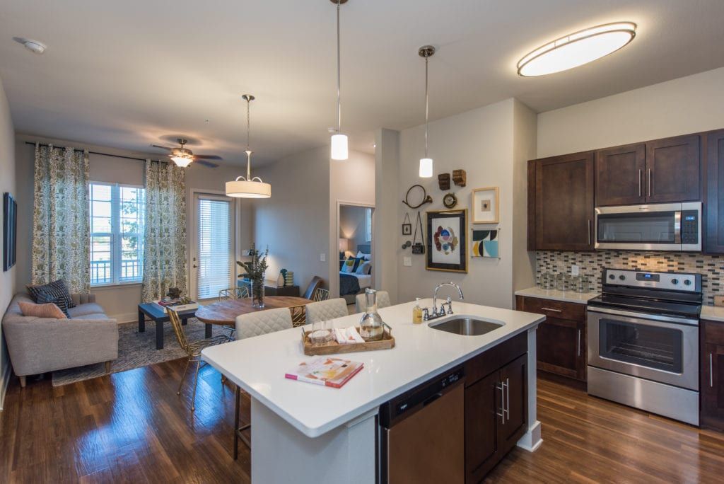 A kitchen with stainless steel appliances and a large island in the middle of the room.