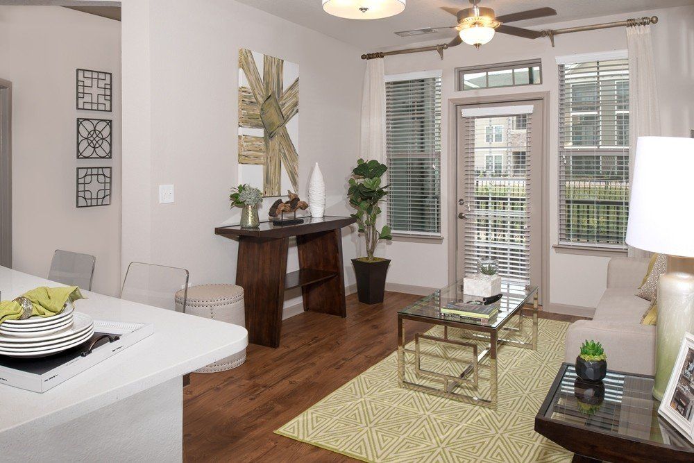 A living room with a couch , coffee table , and a ceiling fan.