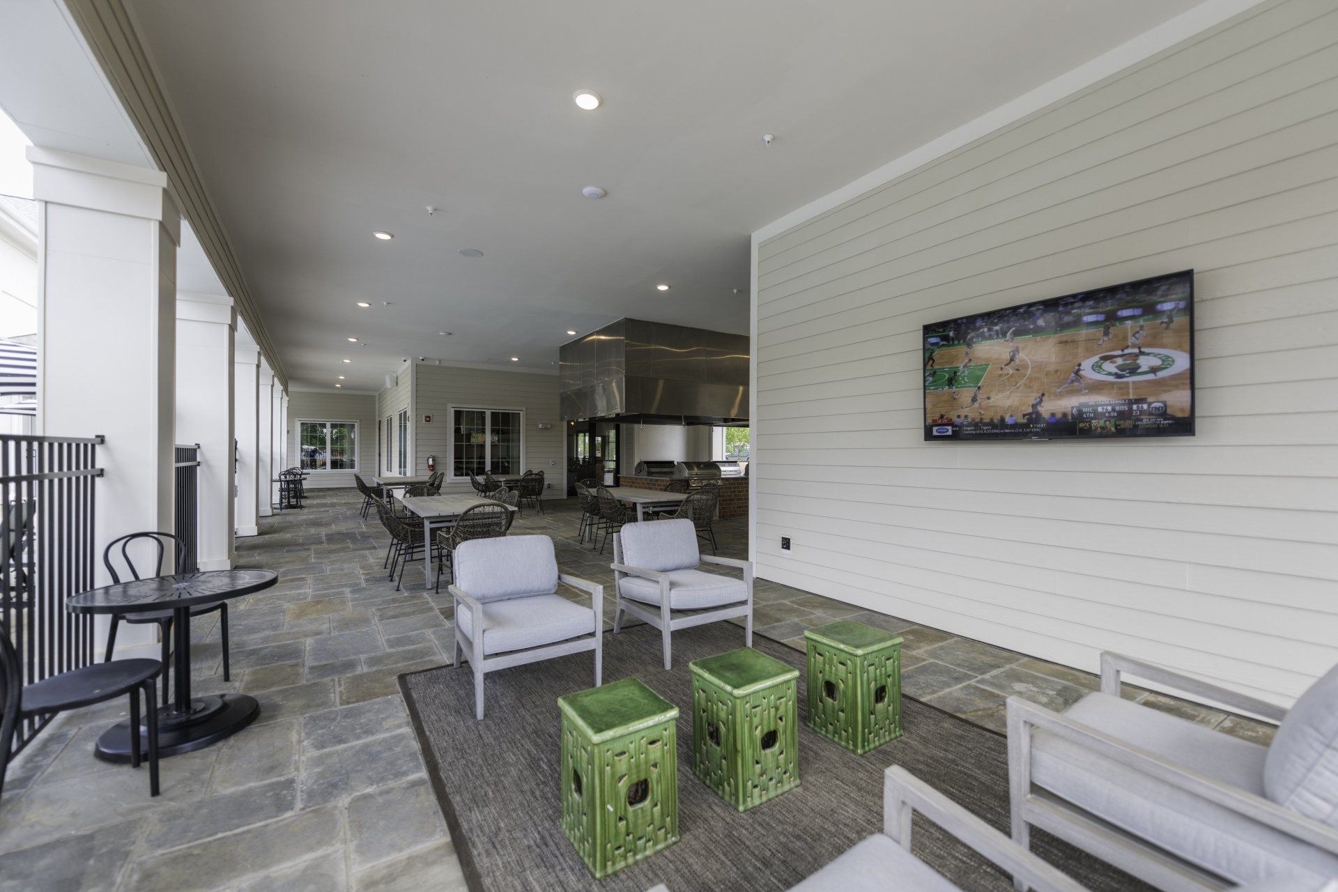 A living room with chairs , tables and a television on the wall.