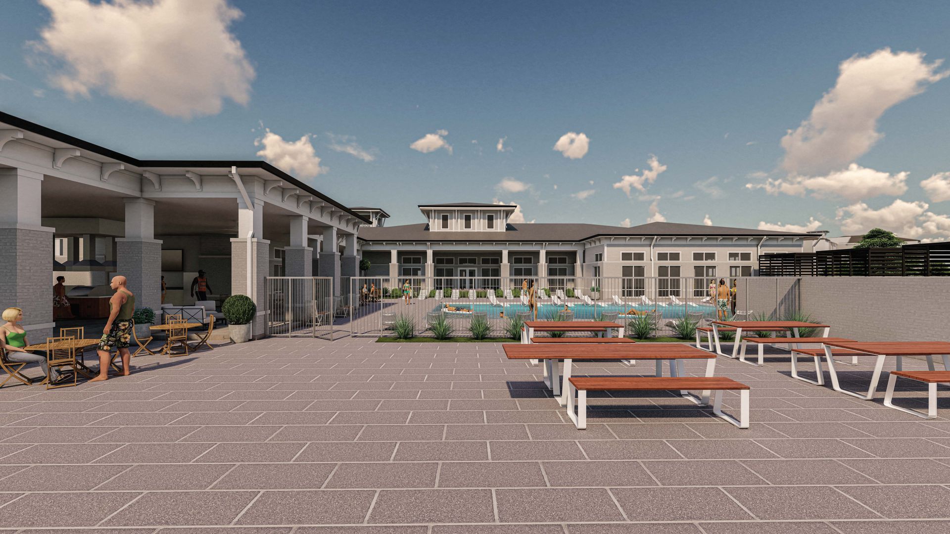 A group of people are sitting at picnic tables in front of a large building.