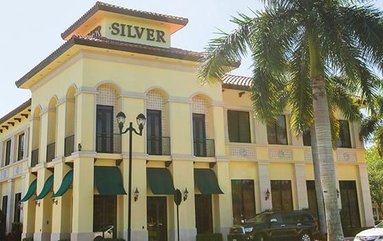 A large yellow building with a sign on top that says silver