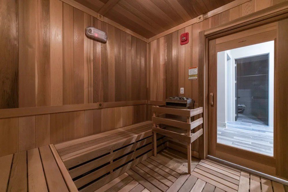A wooden sauna with a glass door and benches.