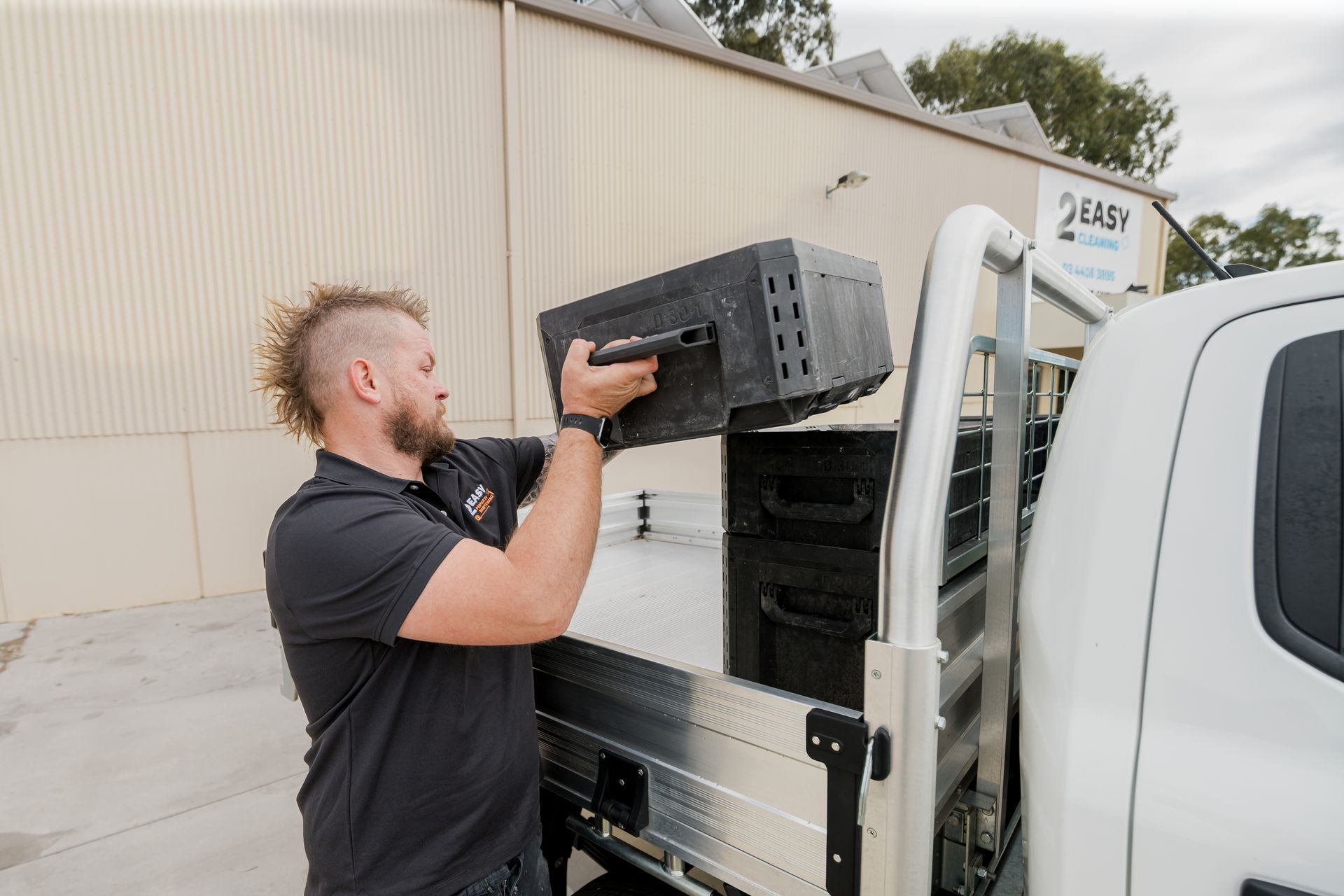 Man Loading Black Containers Into A White Ute - 2easy Property Maintenance in Bendigo, VIC