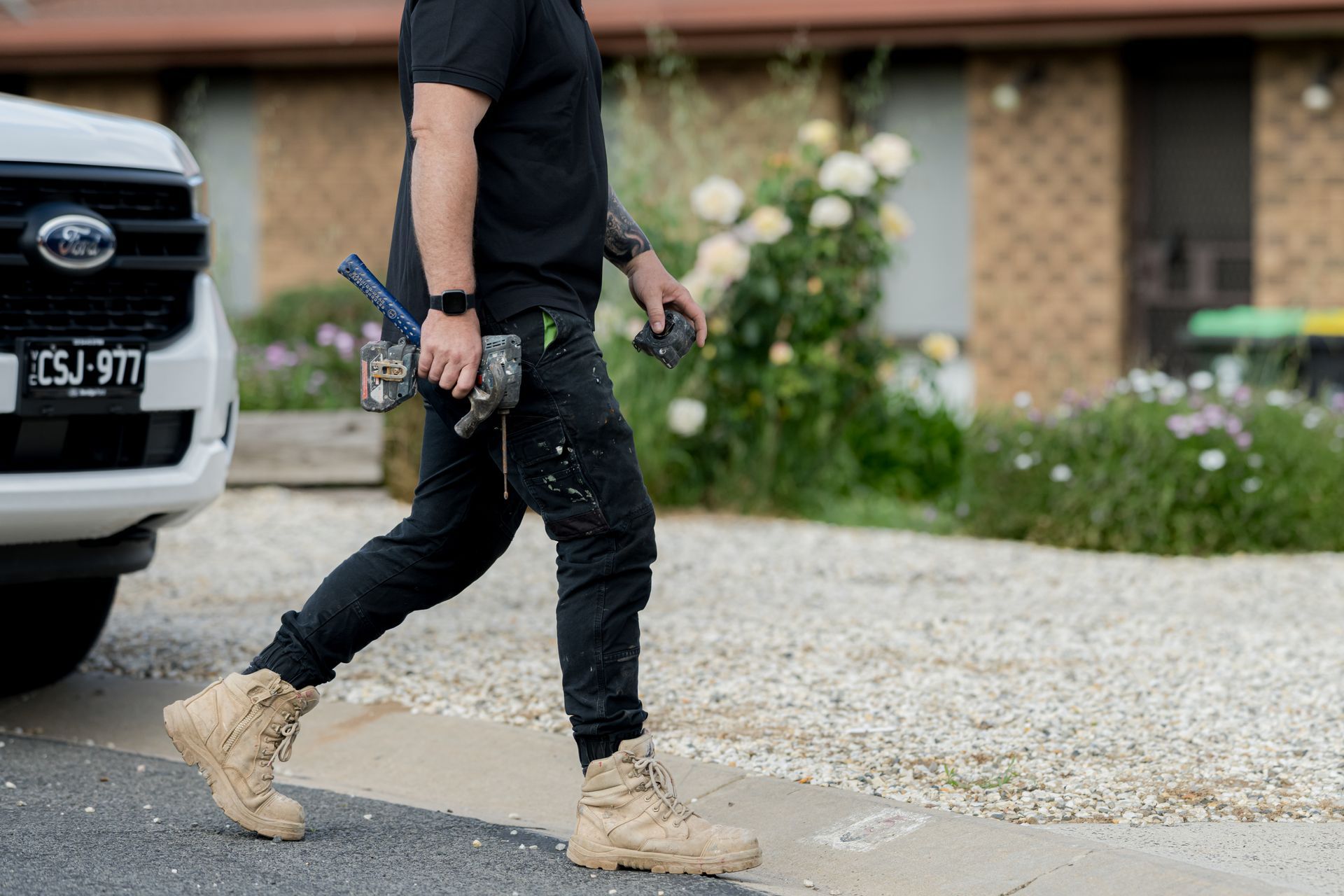 Person with tools walks toward a white vehicle parked in front of a house - 2easy Property Maintenance in Bendigo, VIC