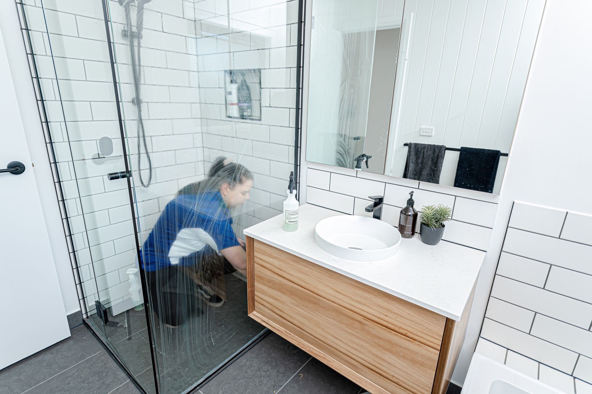 A Woman Is Kneeling In A Bathroom Next To A Sink — 2easy Cleaning in Bendigo, VIC