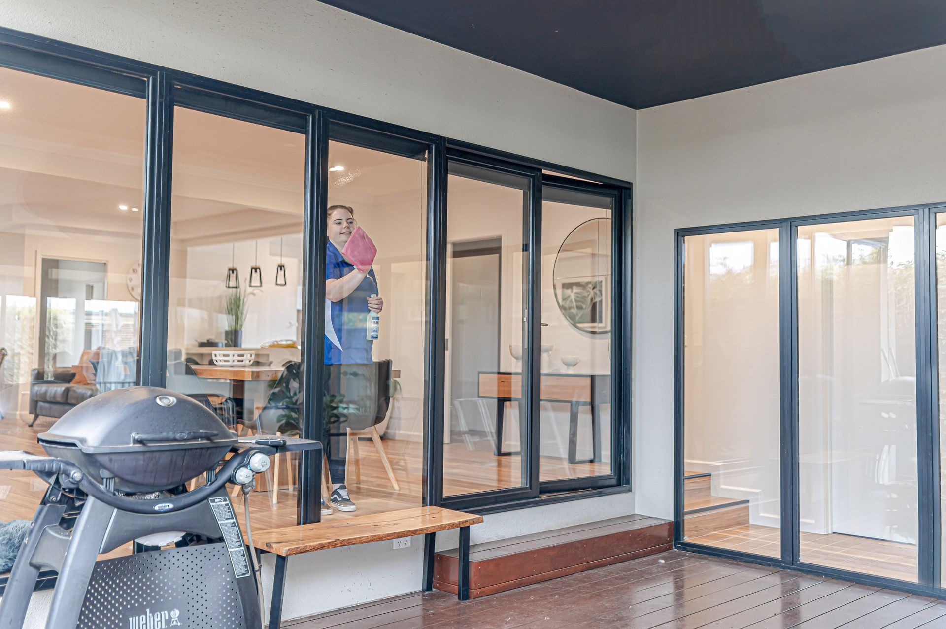 A Man Is Standing in Front of A Large Window on A Balcony  — 2easy Cleaning in Bendigo, VIC