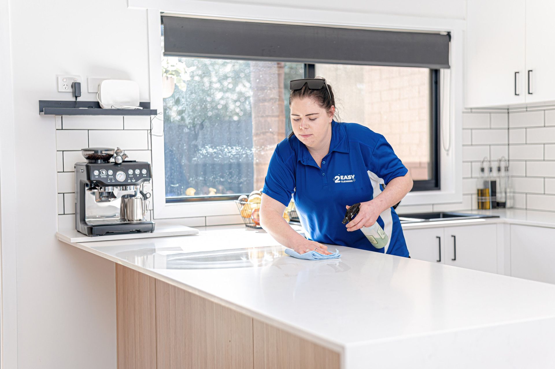 A Woman Is Cleaning The Kitchen Bench — 2easy Cleaning in Bendigo, VIC