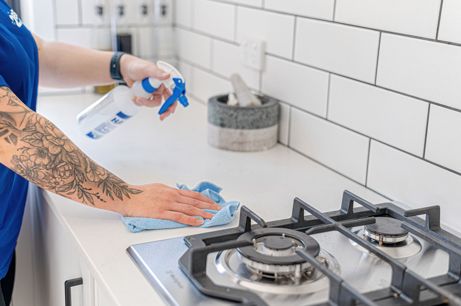 A Woman Is Cleaning A Room With Two Black Couches — 2easy Cleaning in Heathcote, VIC