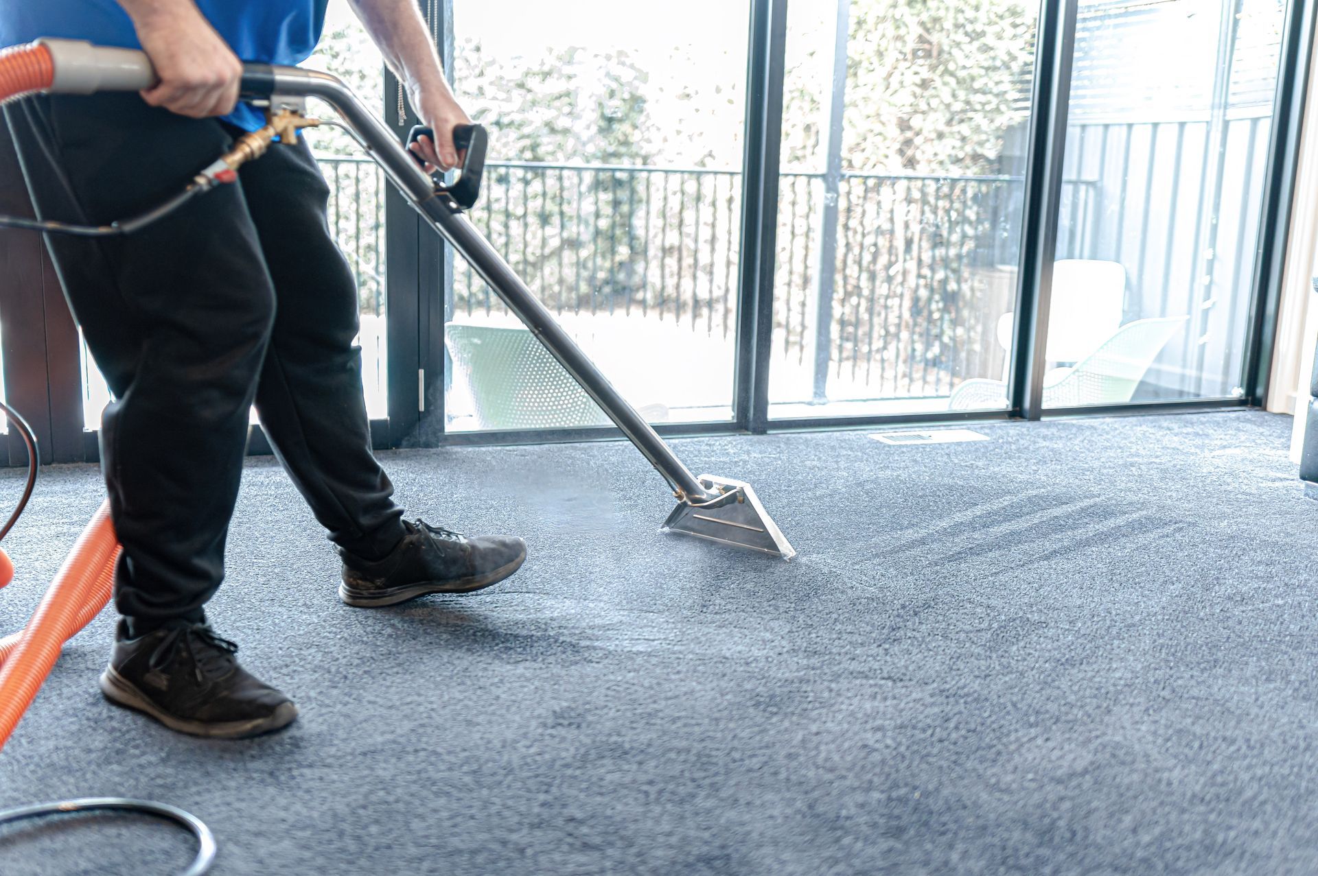 A Man Is Cleaning A Carpet With A Vacuum Cleaner — 2easy Cleaning in Bendigo, VIC