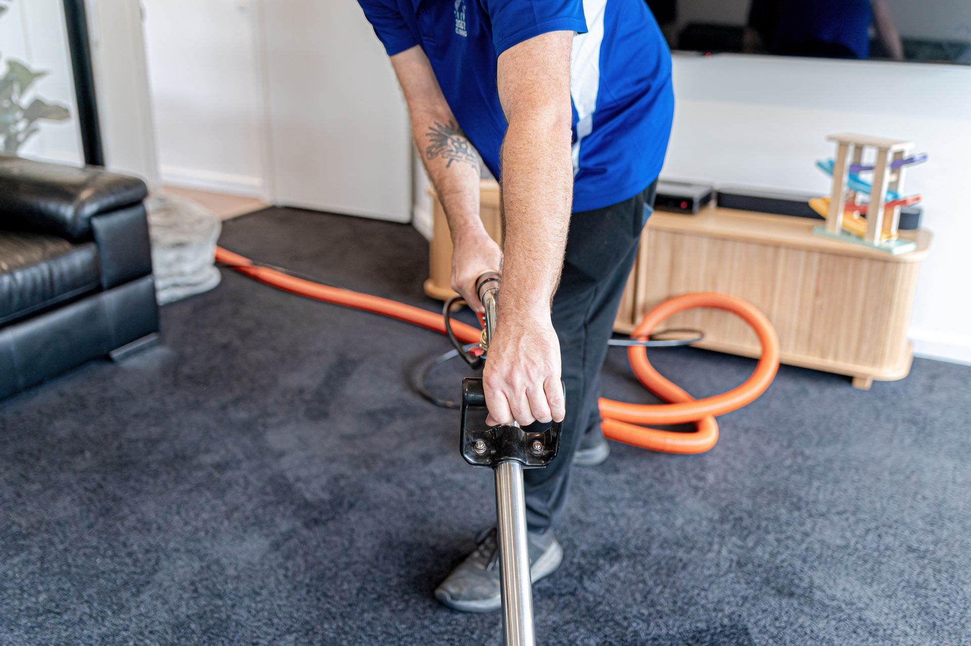 A Man Is Cleaning A Carpet With A Vacuum Cleaner In A Living Room — 2easy Cleaning in Bendigo, VIC