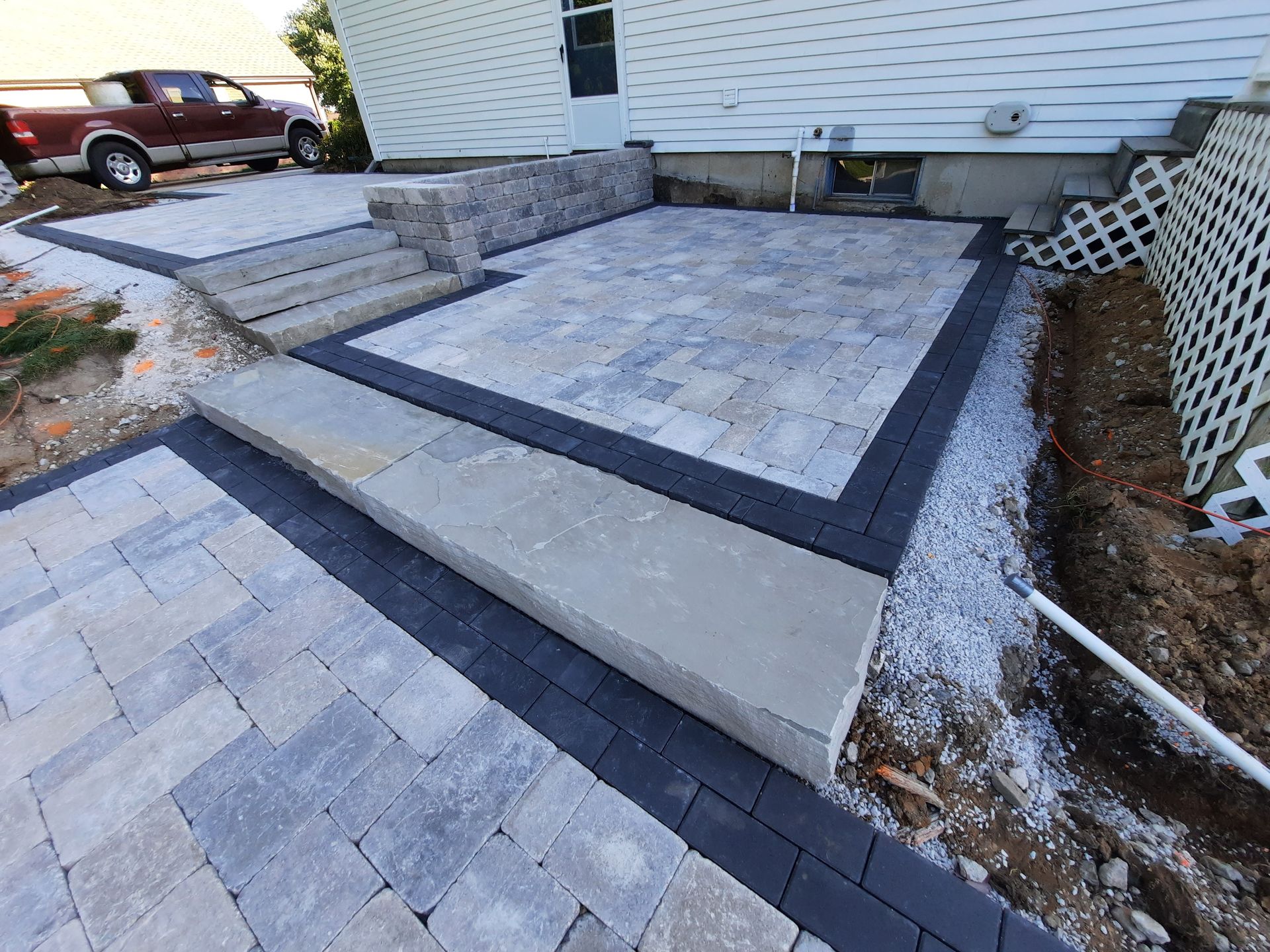 A brick walkway is being built in front of a house.