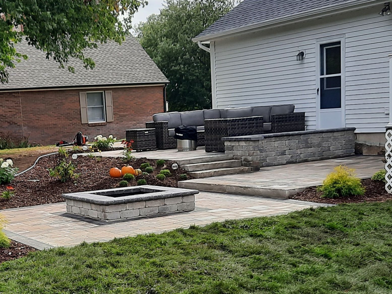 There is a fire pit in the backyard of a house.