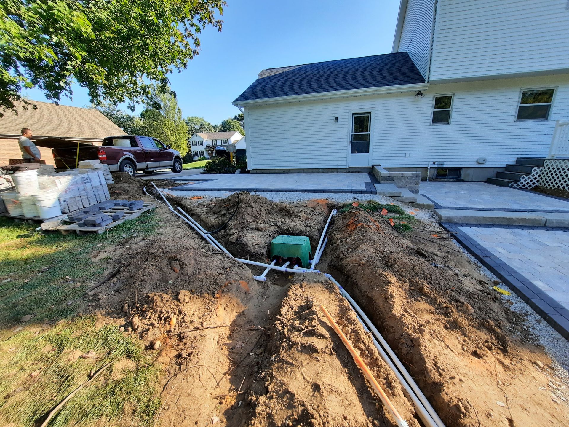 A large hole in the ground in front of a house.