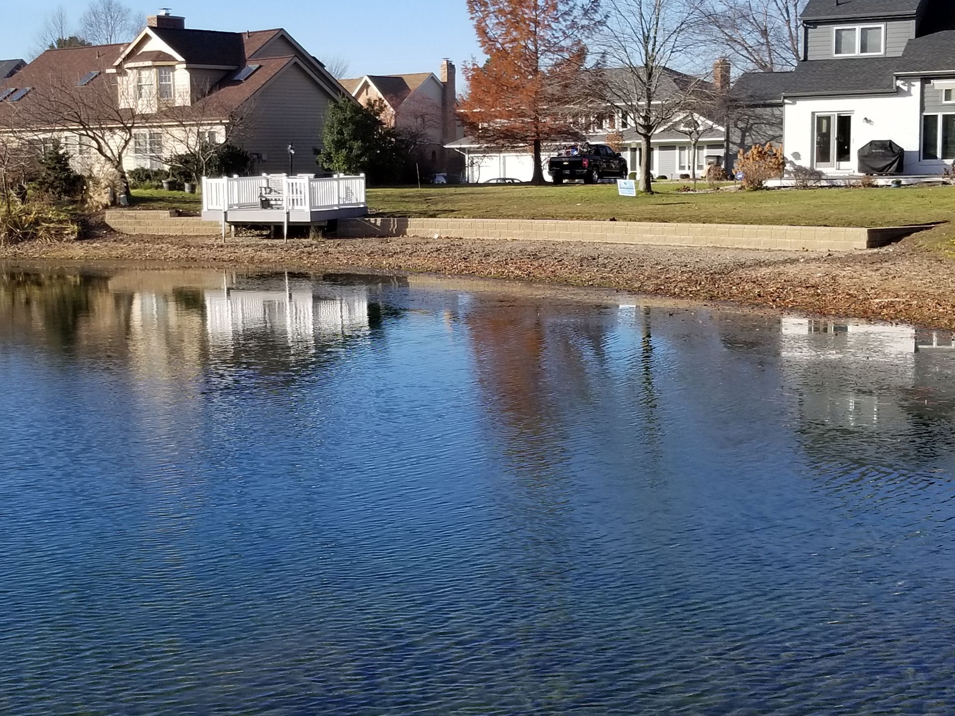 A lake in a residential area with houses in the background