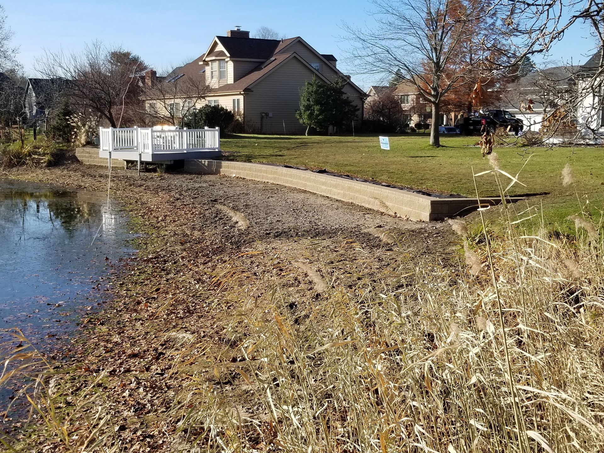 A house is behind a pond with a bridge over it