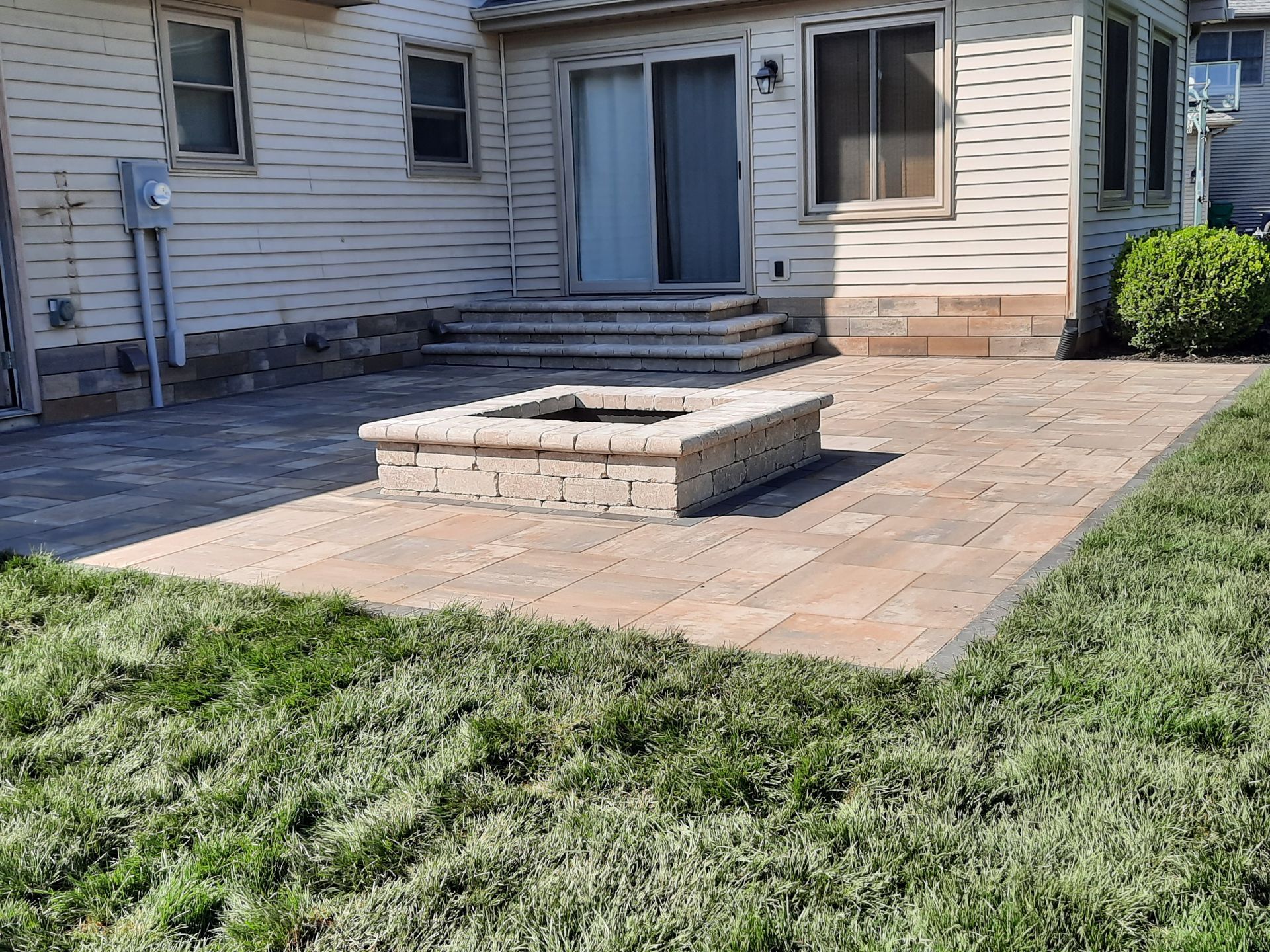 There is a fire pit in the backyard of a house.