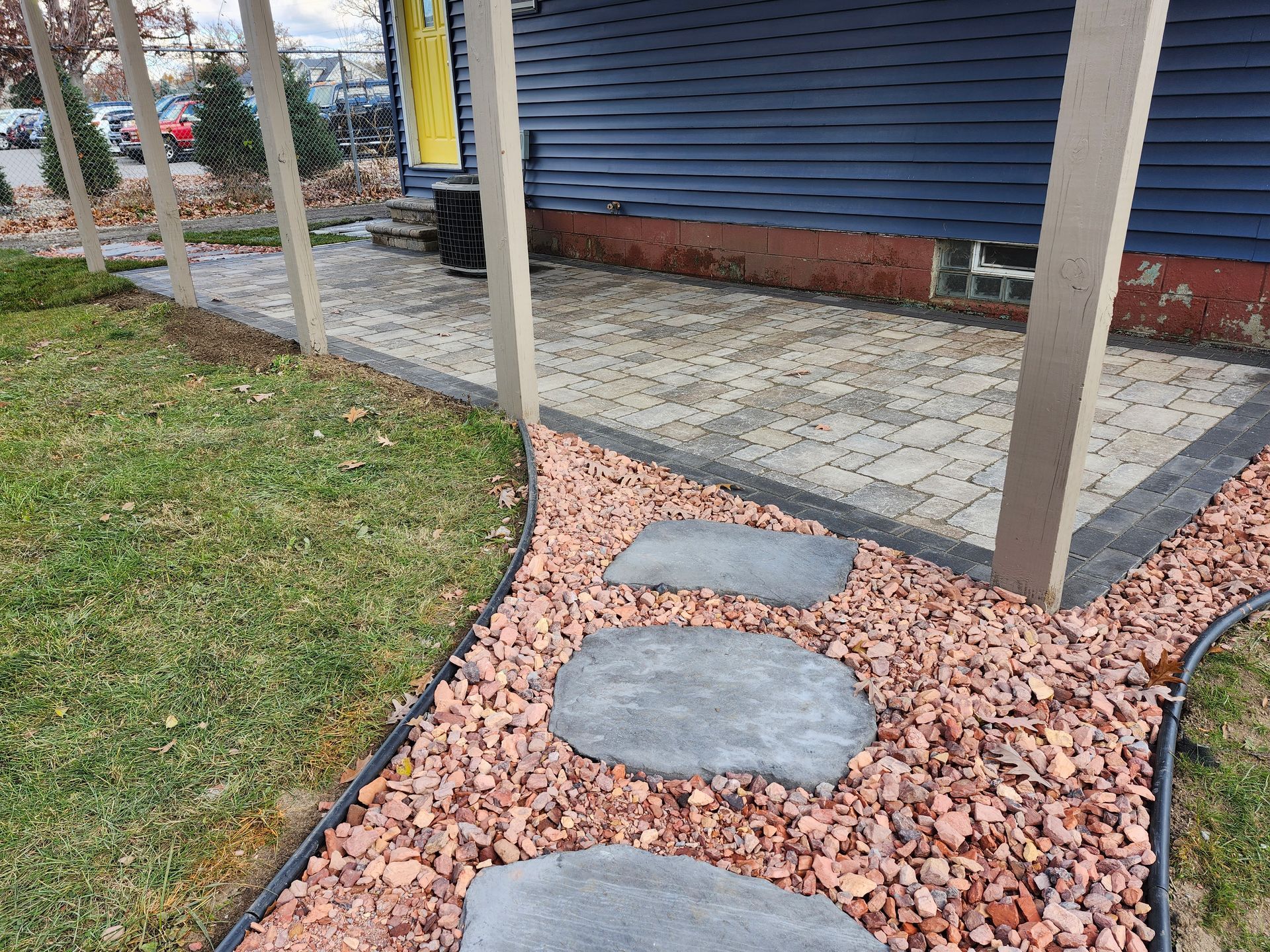 A stone walkway leading to a porch next to a house.