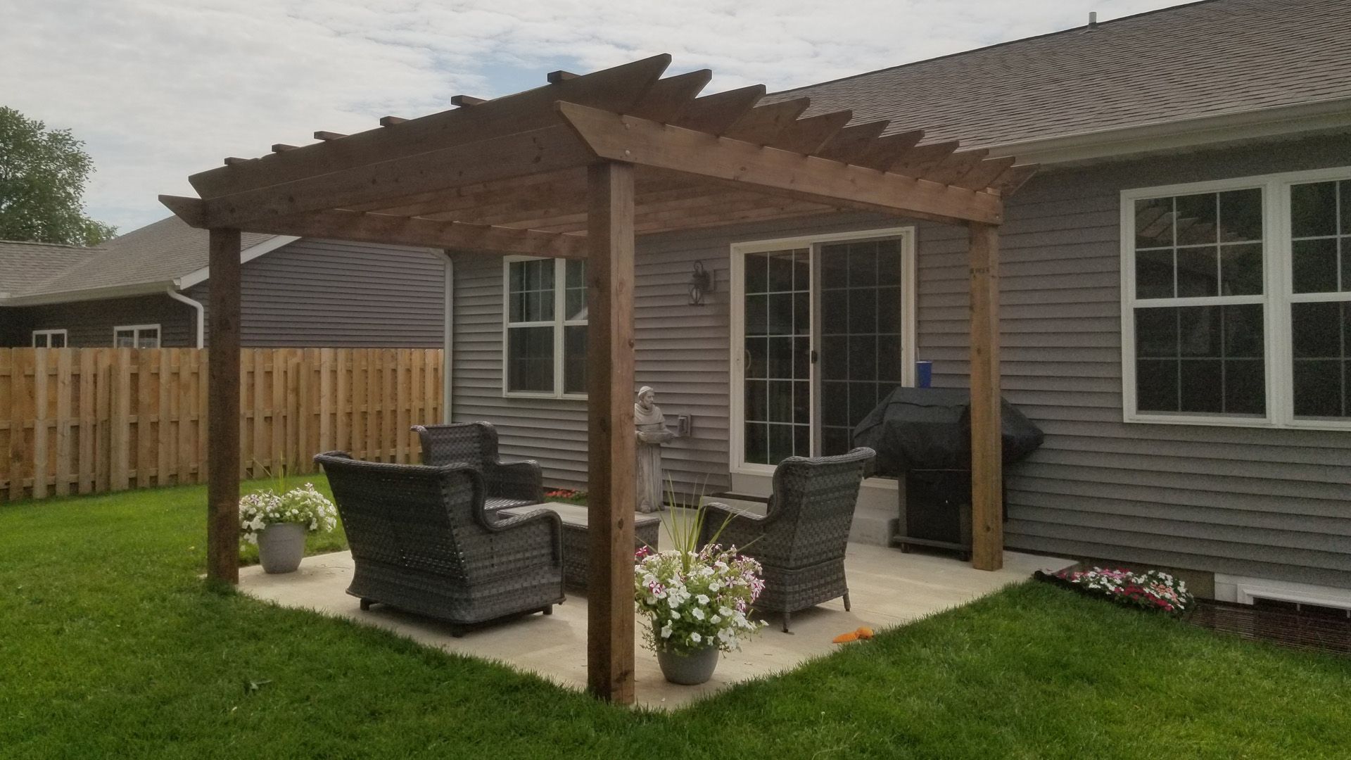 There is a pergola in the backyard of a house.