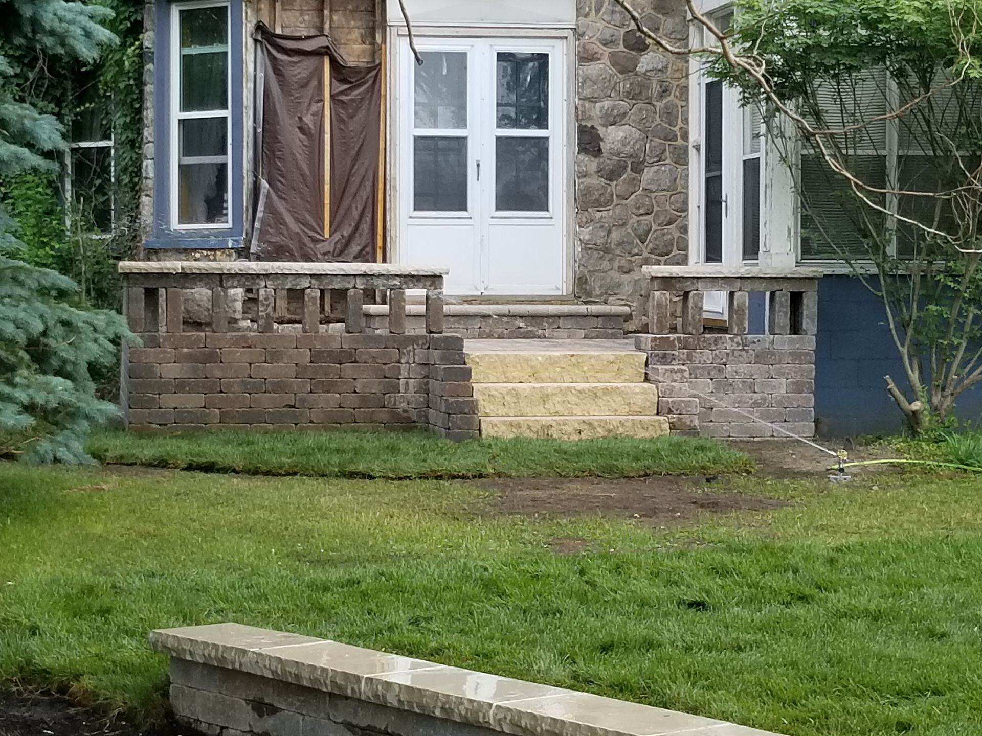 A stone house with stairs leading up to the front door