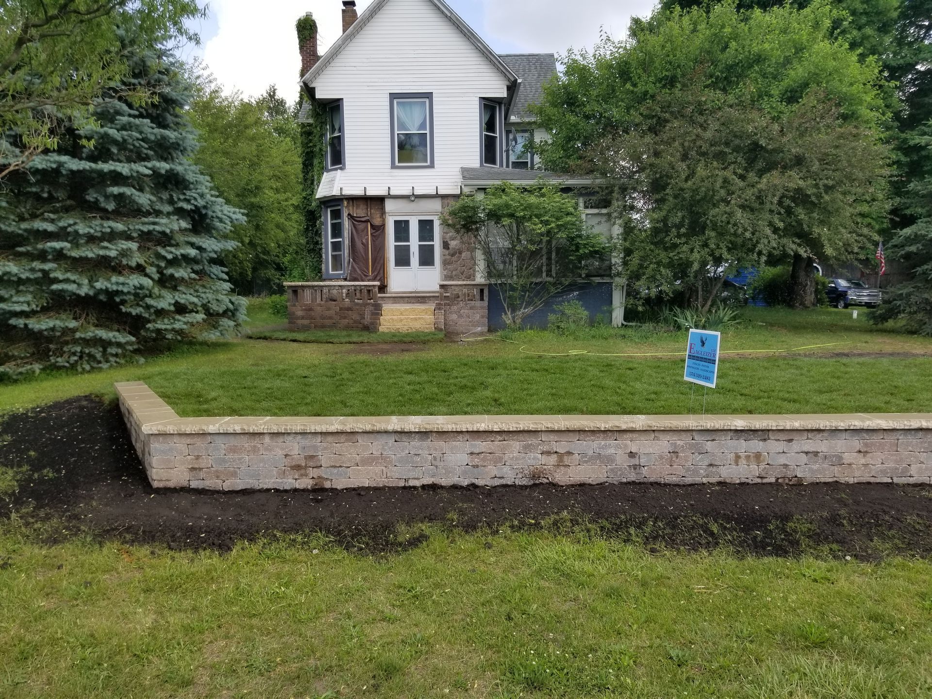 A house with a brick wall in front of it