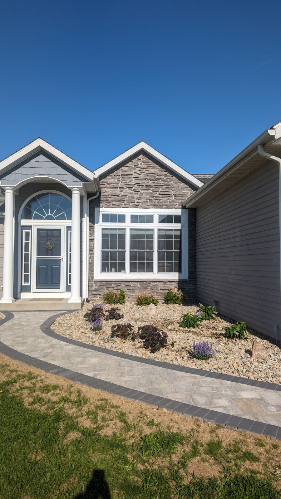 A large house with a walkway leading to the front door.
