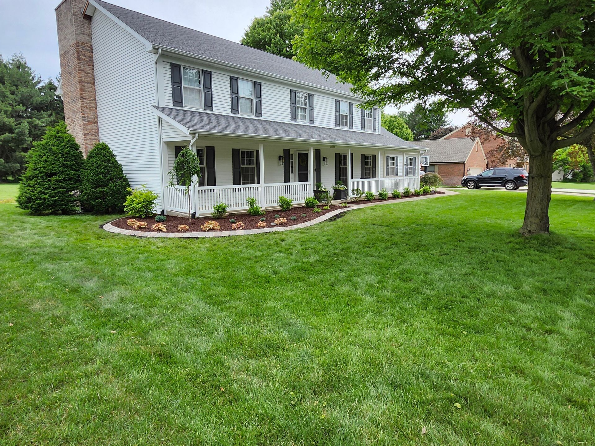 A large white house with a large lawn in front of it.