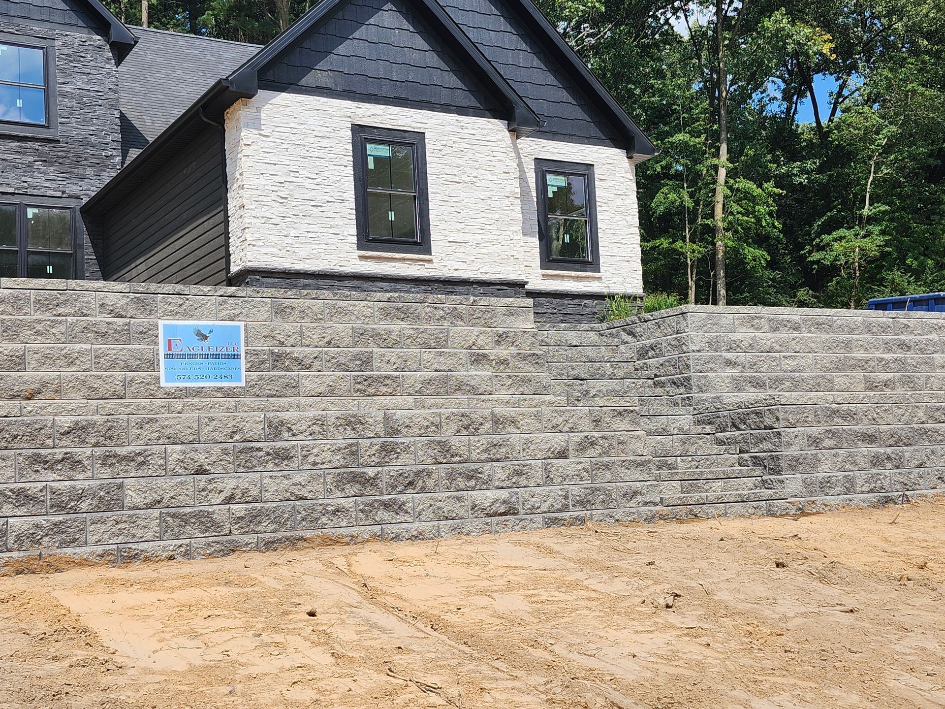 A large house with a brick wall in front of it.