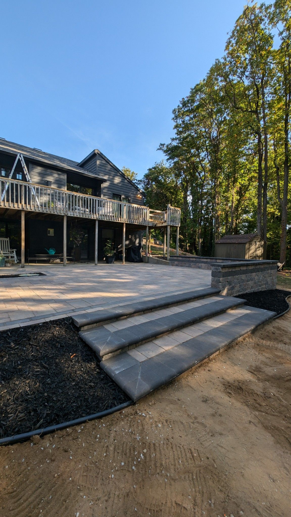 A large house with a large deck and stairs leading to it.