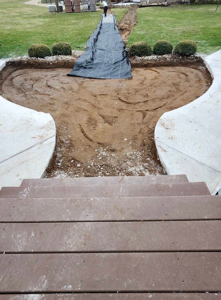 A person is laying a tarp over a concrete walkway in a yard.