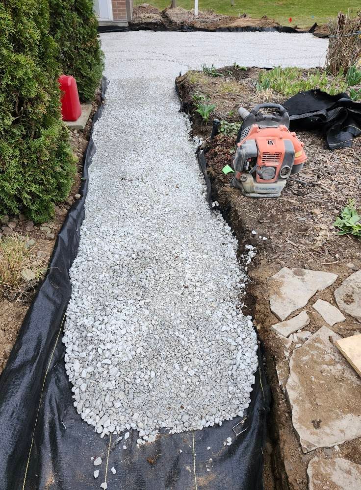 A lawn mower is sitting on top of a pile of gravel.